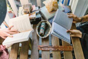 The picture shows 2 people reading books about magic.