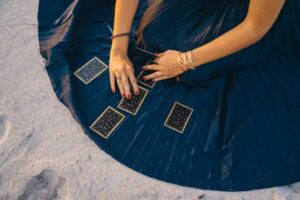 The picture shows a person unfolding Tarot cards - preparing to cast a spell.