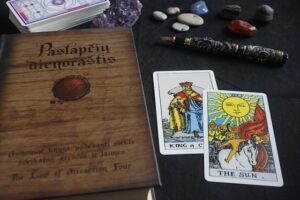 In the picture we see 2 Tarot cards and a magic book.