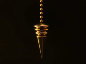 The photo shows a gold-colored pendulum