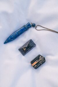 The picture shows a pendulum and two crystals.